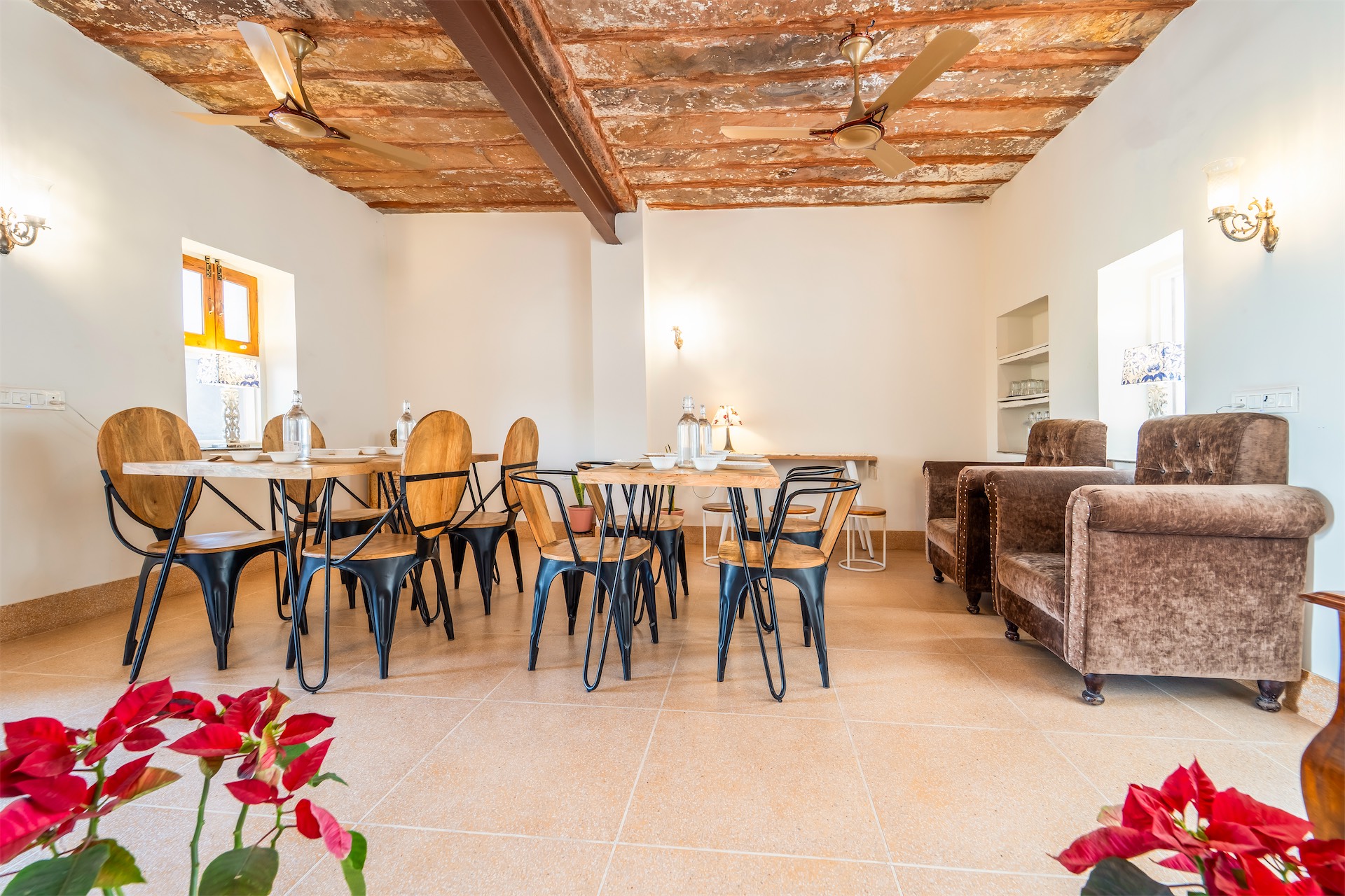 Spacious dining hall with red flowers and cozy seating