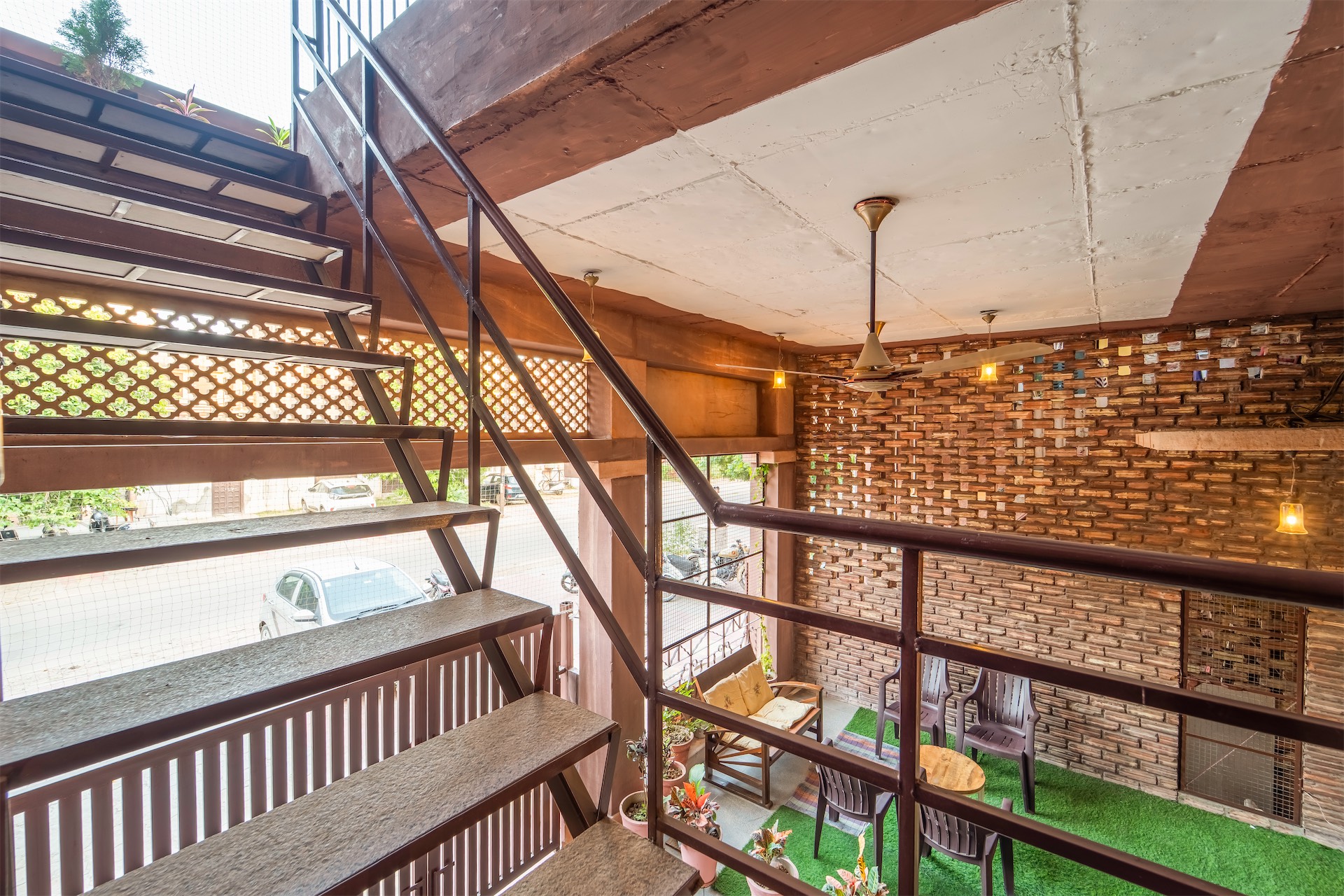 Open staircase with jali screen and brick wall